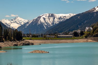 Davos Gölü Panoraması-Isviçre güneş ve mavi gökyüzünde baharda Alpler 'in yüksek kısmi karlı dağları ile