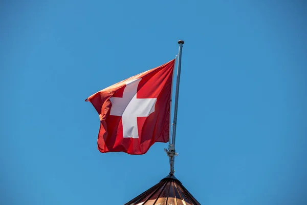 Obrázek Švýcarské Vlajky Foukající Větru Před Modrou Oblohou — Stock fotografie