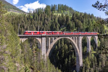 Davos-Wiesen, İsviçre-07 Haziran 2019 İsviçre Alpleri kenti yakınlarındaki Rhaetian Demiryolu treniyle tarihi Wiesener Viyadüğü'nden görünüm