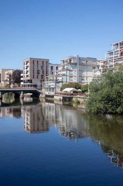 Leipzig sahne ilçe Schleussig modern konut binaları mavi gökyüzü ve güneş ışığı ile köprü ile nehir Elster doğrudan