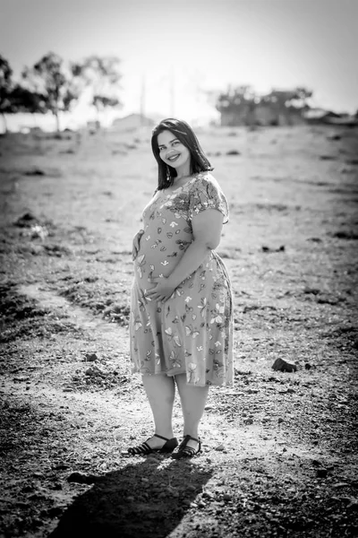 Pregnant woman in black and white outdoor - Holding belly