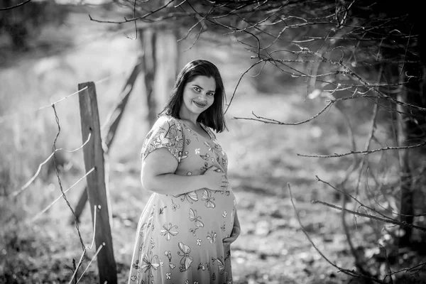Pregnant woman in black and white outdoor - Holding belly