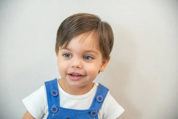 Şirin bebek çocuk yürümeye başlayan çocuk - beyaz arka planda - mavi romper ile gülümseyen