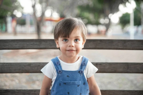 ロンパー ベンチに庭のかわいい赤ちゃんの少年幼児 — ストック写真