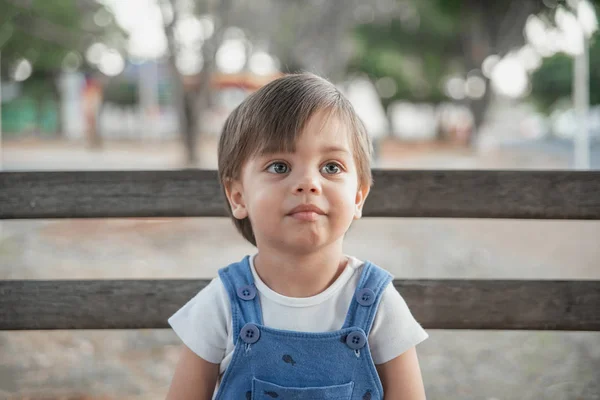 ロンパー ベンチに庭のかわいい赤ちゃんの少年幼児 — ストック写真