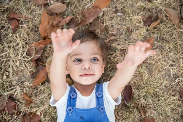 かわいい赤ちゃん男の子幼児 乾いた草の上に横たわる — ストック写真