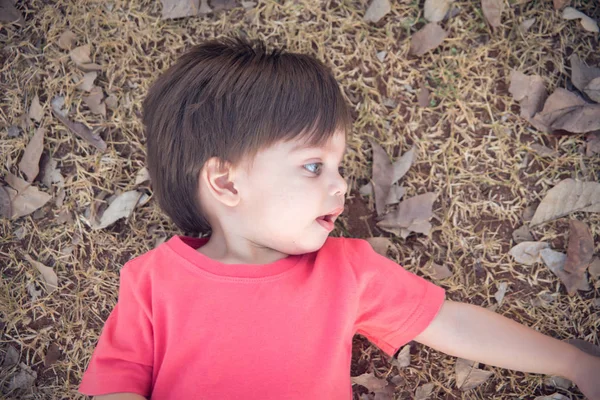 かわいい赤ちゃん男の子幼児 乾いた草の上に横たわる — ストック写真