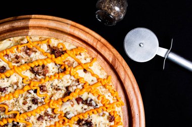 Yakın çekimde siyah bir arka plan üstüne yarım pizza