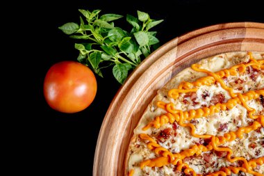 Yakın çekimde siyah bir arka plan üstüne yarım pizza