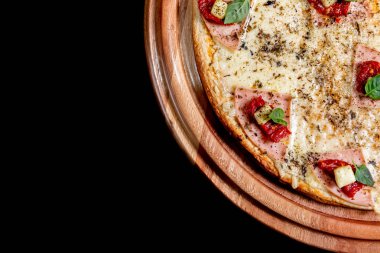 Yakın çekimde siyah bir arka plan üstüne yarım pizza