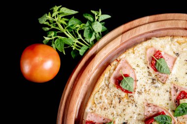 Yakın çekimde siyah bir arka plan üstüne yarım pizza