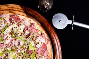 Yakın çekimde siyah bir arka plan üstüne yarım pizza