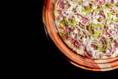 Yakın çekimde siyah bir arka plan üstüne yarım pizza