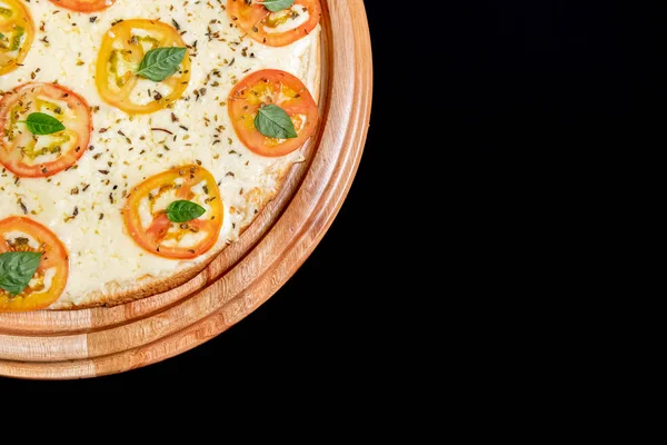 Meia pizza em cima de um fundo preto de perto — Fotografia de Stock