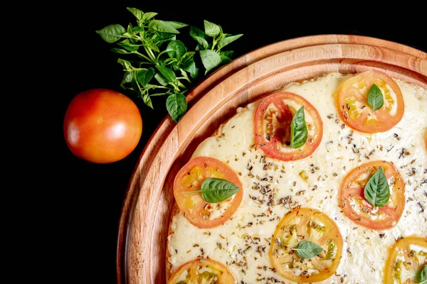 Meia pizza em cima de um fundo preto de perto — Fotografia de Stock