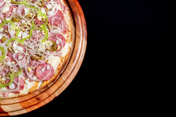 Meia pizza em cima de um fundo preto de perto — Fotografia de Stock