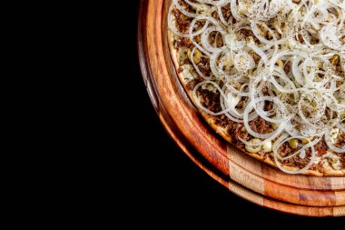 Yakın çekimde siyah bir arka plan üstüne yarım pizza