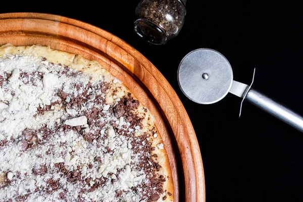 Meia pizza em cima de um fundo preto de perto — Fotografia de Stock