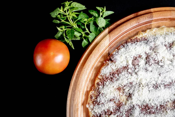 Yakın çekimde siyah bir arka plan üstüne yarım pizza