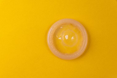 Sarı arka planda lateks prezervatif