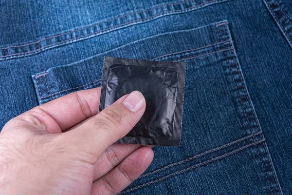 Uomo Che Tiene Preservativo Vicino Alla Tasca Dei Jeans — Foto Stock