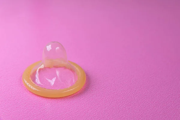 粉色背景的乳胶避孕套 — 图库照片