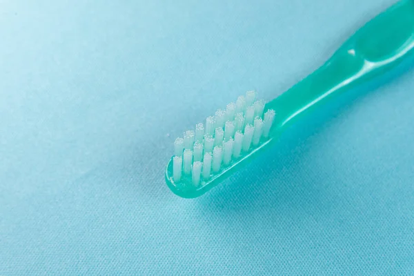 青の背景に緑の歯ブラシ — ストック写真
