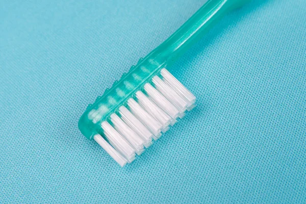 青の背景に緑の歯ブラシ — ストック写真