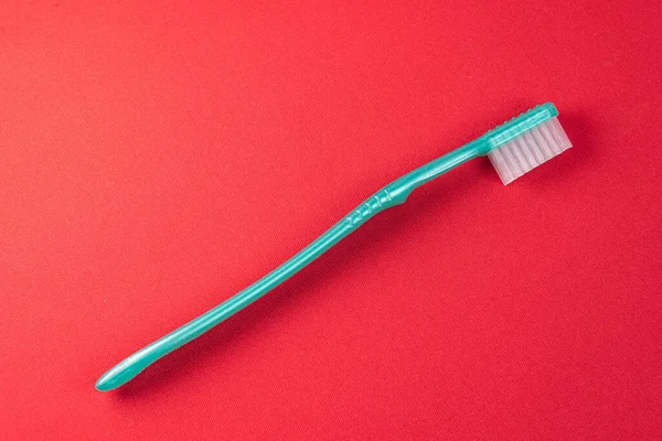 Green Toothbrush Red Background — Stock Photo, Image