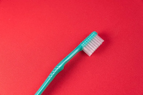 Green Toothbrush Red Background — Stock Photo, Image