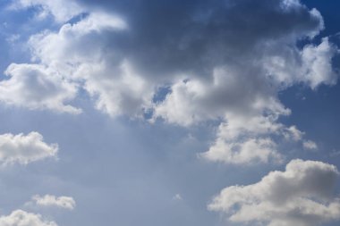 Bulutlar. Gün batımında parlak bir gökyüzüne karşı bulutların arasından güneşin ışığı. Mavi gökyüzündeki bulutlar. Günbatımı.