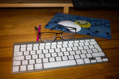 Klavye, mousepad, gözlük ve kalemin ahşap oyun tahtası 