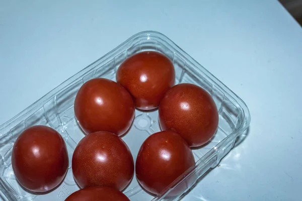 Rode Tomaten Een Plastic Doos Geïsoleerd Witte Tabel — Stockfoto