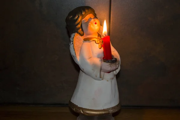 Anjo de porcelana com vela vermelha ardente — Fotografia de Stock