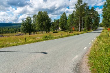 İsveç / İsveç 'in küçük bir köyü olan Nordmark' tan geçen ana yol güneşli bir günde
