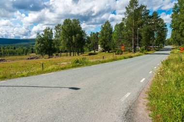 İsveç / İsveç 'in küçük bir köyü olan Nordmark' tan geçen ana yol güneşli bir günde