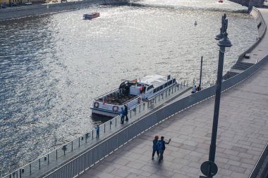 Moskova, Rusya - 31 Temmuz 2020: Moskva Nehri manzarası ve Zaryadye Parkı 'nda yüzen yaya köprüsünden bir turist teknesi