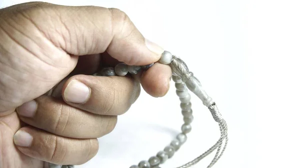 Beyaz arka plan üzerinde izole tespih tutan adam