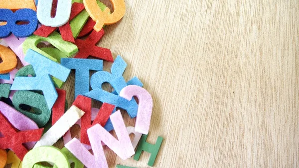 Ahşap arka plan üzerinde renkli harfler