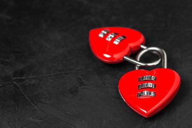 Sevgililer günü arka plan. İki kırmızı kalp şekli kodu asma kilitler siyah dokulu arka plan üzerinde kopya alanı ile.