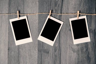 İp üzerinde ahşap arka plan asılı boş alanı ile boş vintage anlık fotoğraf.