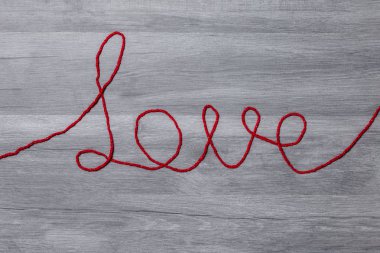 Sevgililer günü. Ahşap arka plan üzerinde kırmızı yün metin seviyorum