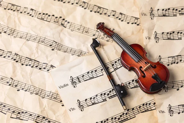 Violin on vintage music notes paper background with copy space