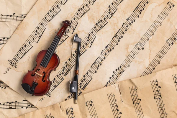Violin on vintage music notes paper background with copy space