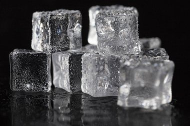 Yığın yakın / su buz erime kazık damla siyah arka plan üzerine