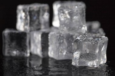 Yığın yakın / su buz erime kazık damla siyah arka plan üzerine