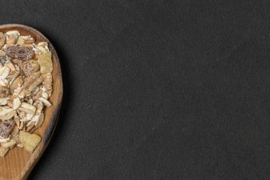 Üst görünüm. Kopya alanı ile siyah plaka üzerinde müsli ahşap kaşık