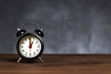 Saat 6 yönünde alarm saati 1. Koyu arka planda kopya alanı ile ahşap masada Vintage/Retro siyah analog çalar saat