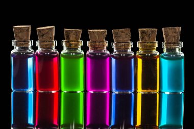 Siyah arka plan üzerinde izole şeffaf renkli kimyasal sıvı ile küçük şişe satır