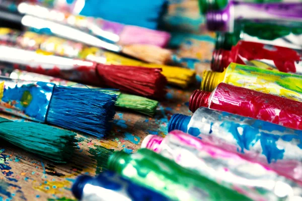Χρωματισμένα Πινέλα Ζωγραφικής Και Ακρυλικές Σωλήνες Πόνου Στο Τραπέζι Του — Φωτογραφία Αρχείου